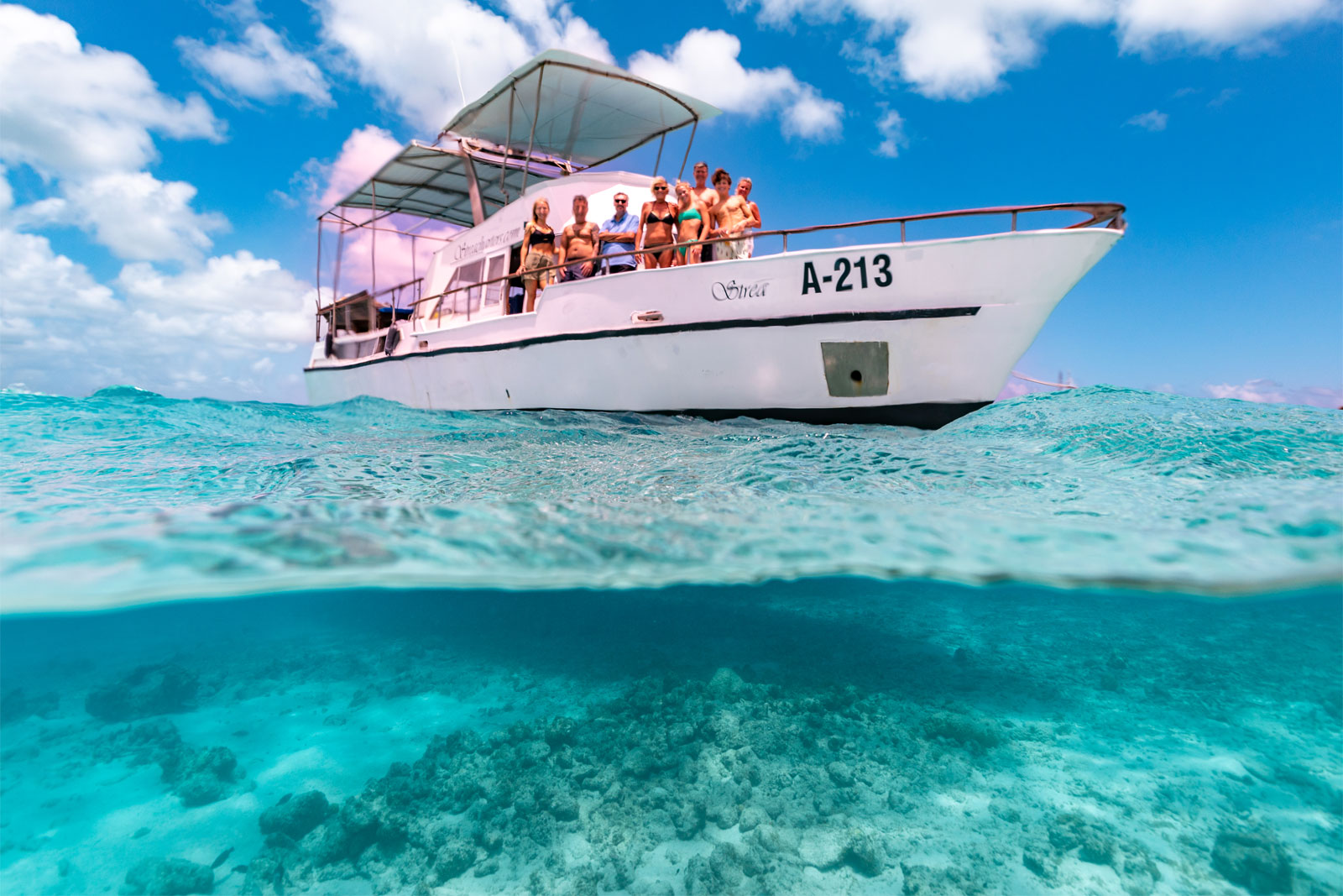 strea charters boat on the crystal blue waters. Picture is half above water, half under water.